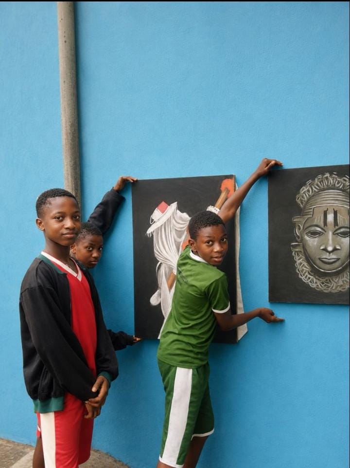 Students displaying their fine art paintings on the school wall